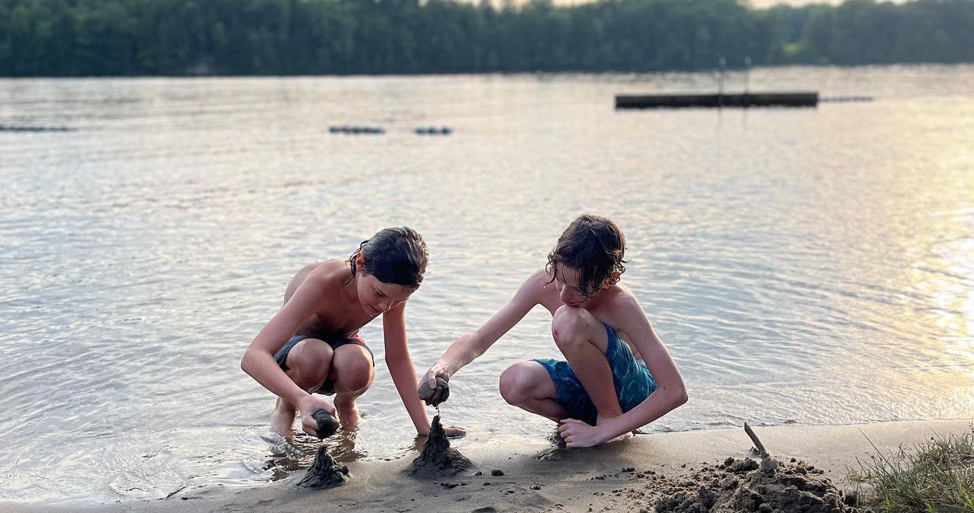 The boys playing at the lake's edge at golden hour in Muskoka